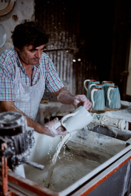 potter glazing jugs in Corval pottery village in portugal