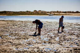 couple searching for beach worms in the sand in the Portugese Algarve