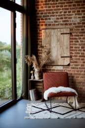 lounge chair in the corner of a renovated old barn at sunset