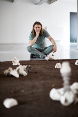 ceramist sitting on the floor behind his ceramics