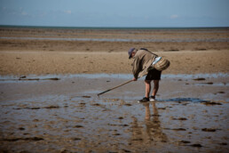 man looking for vongole at the beach at low tide